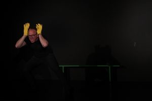 Schauspielunterricht im TheaterLabor TraumGesicht: Peter in schrwarzer Übungskleidung auf der Probebühne übt starke Hand- und Körpergebärden. Er trägt goldgelbe Glitzerhanschuhe.