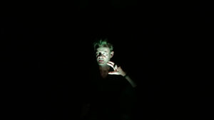 Lars WEllings in der Rolle des Lenz. Völlig dunkler Raum, Nur ein Spot ist auf sein Gesicht gerichtet.