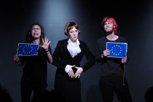 Drei Schüler zeigen eine Szene aus ihrem Programm Kabarettungsdienst KLIMAX. In der Mitte wird die Kanzlerin und links und rechts von ihr werden Europapolitiker karikiert.