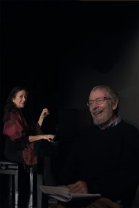 Sybille Karrasch am Klavier und wolfgang Keuter sitzt vorne rechts im Bild. Beide lachen.
