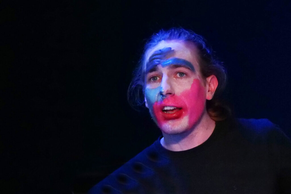 Teilnehmer steht im blauen Bühnenlicht während des Schauspielprojekts Dein Solo im Theaterlabor Düsseldorf.
